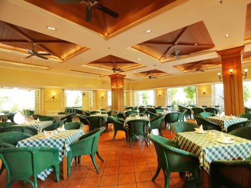 une salle à manger avec des tables et des chaises vertes dans l'établissement Palm Beach Resort & Spa, à Sanya