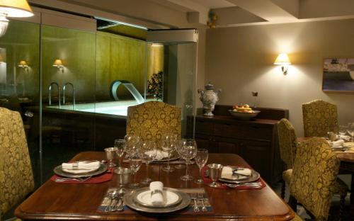 Le Convivial - Wine and Spa Experience Suites في غزيلوكاسترون: غرفة طعام مع طاولة مع كؤوس للنبيذ