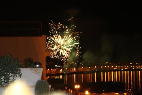 a firework display in front of the water at night at B&B Punta Cutieri in Gallipoli