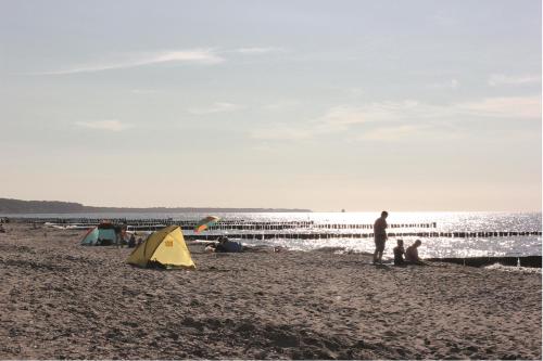 a group of people on a beach with a tent at Ostseedomizil La Mer in Börgerende-Rethwisch