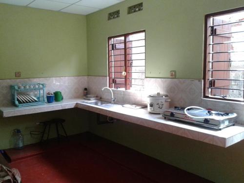 eine Küche mit Spüle und zwei Fenstern in der Unterkunft Didula Holiday Resort in Anuradhapura