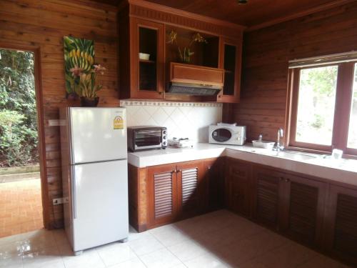 a kitchen with a white refrigerator and a microwave at Baan Laem Noi Villa's in Mae Nam