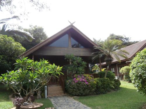 a house with trees and plants in front of it at Baan Laem Noi Villa's in Mae Nam