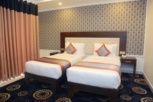 a hotel room with two beds in a room at Galaxy Grand Hotel in Nuwara Eliya