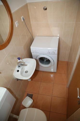 a bathroom with a washing machine and a sink at Apartments Seka in Hvar