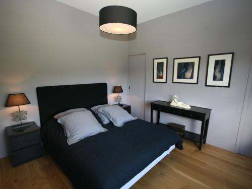 Un dormitorio con una cama y una mesa con una lámpara. en Luxurious Villa in Pont-Aven with Private Pool, en Pont-Aven