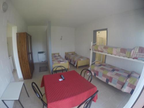 a room with a table and two bunk beds at Camping Villaggio Paradiso in Domaso