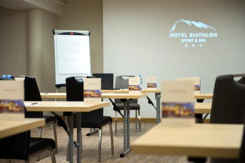 a classroom with tables and chairs and a screen at Hotel Biathlon Sport & Spa in Szklarska Poręba