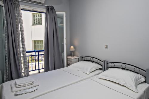 1 dormitorio con cama blanca y ventana en Cozy flat in Tinos, en Tinos