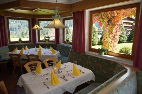 un comedor con mesas, sillas y ventanas en Ferienhotel Iris, en Auffach