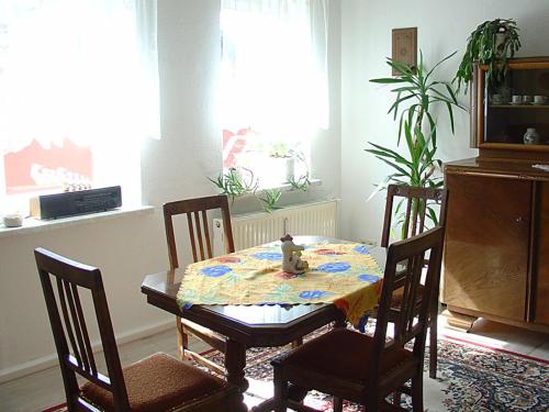 a dining room with a table and chairs with a teddy bear on it at Hotel-Pension Königswald in Dresden