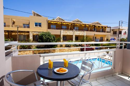 a table and chairs on the balcony of a apartment at Anna Maria Hotel in Platanias