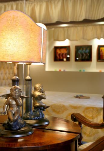 a lamp on a table with two little children on it at Great Greece Le Convivial Suites in Xylokastron