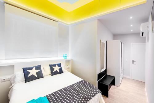 a bedroom with a bed and a yellow ceiling at Apartamento Greco Toledo in Toledo