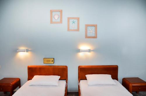 two beds in a room with lights on the wall at Hermes in Kalymnos