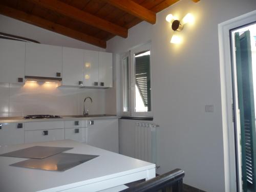 een keuken met witte kasten en een wit aanrecht bij Cegi's home in Vernazza