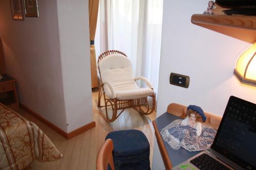 a room with a chair and a desk with a laptop at Hotel La Bussola in Andalo