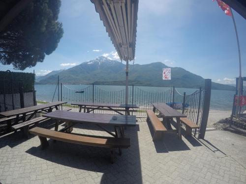 a group of picnic tables with a view of the water at Camping Villaggio Paradiso in Domaso