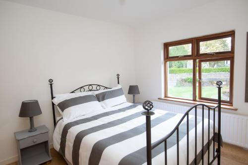 a bedroom with a black and white bed and a window at Luskin's in Cong