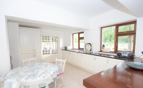 a white kitchen with a table and a counter top at Luskin's in Cong