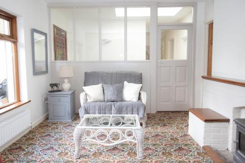 a white living room with a chair and a table at Luskin's in Cong