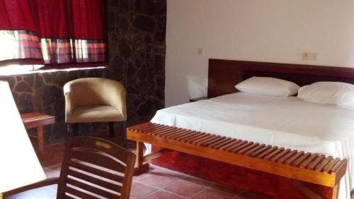 a bedroom with a bed and a chair and a table at The Rock House in Katunayake