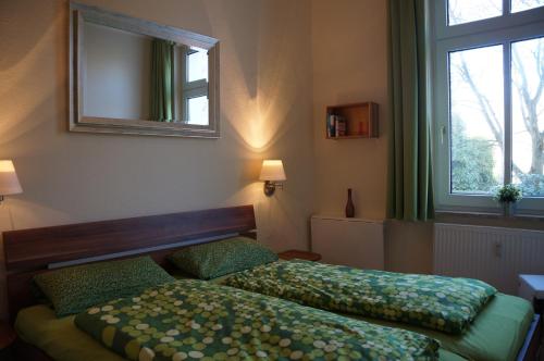 1 Schlafzimmer mit 2 Betten, einem Spiegel und einem Fenster in der Unterkunft Ferienwohnung Sandrose in Wangerooge