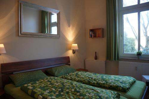 ヴァンガーオーゲにあるFerienwohnung Sandroseのベッドルーム1室(ベッド2台、鏡、窓付)