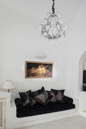 a living room with a couch with a chandelier at Above Blue Suites in Imerovigli
