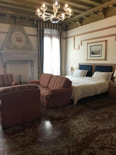 a bedroom with a bed and a couch and a bed at Foscari Palace in Venice