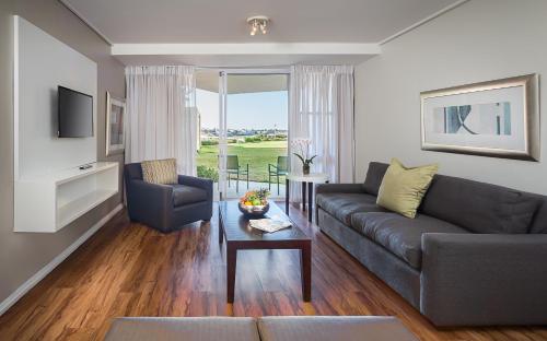 a living room with a couch and a table at Lagoon Beach Hotel & Spa in Cape Town