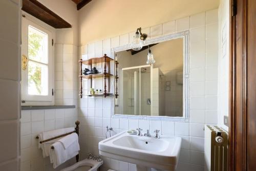 a white bathroom with a sink and a toilet at Villa Serena & Dépendances in Cortona