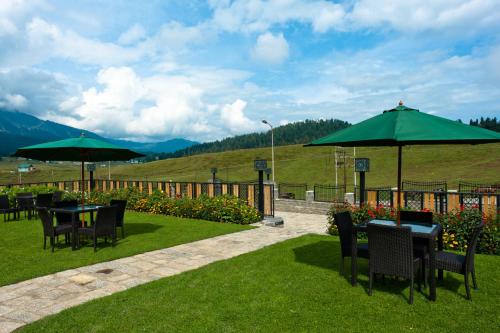 a patio with tables and chairs and umbrellas at The Vintage Gulmarg in Gulmarg