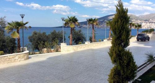 a car driving down a road next to a body of water at White Residence Apartament in Sarandë