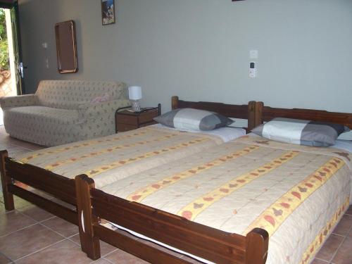 a bedroom with a large bed and a chair at Anastasis Apartments in Trapezaki