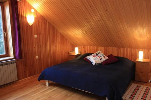 a bedroom with a bed in a wooden room at Apartment Pogled in Skrad