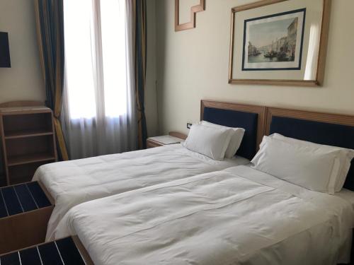 a bedroom with a large bed with white sheets at Foscari Palace in Venice
