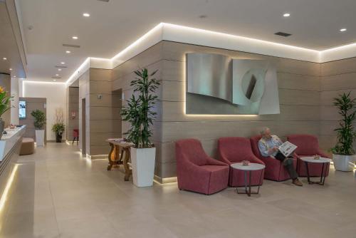 a woman sitting on a couch in a lobby at Hotel La Giocca in Rome