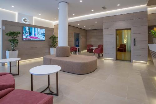 a lobby with a couch and tables and chairs at Hotel La Giocca in Rome