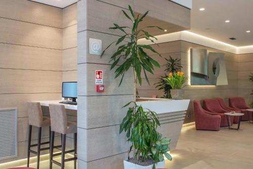 a lobby with a bar with stools and a tv at Hotel La Giocca in Rome