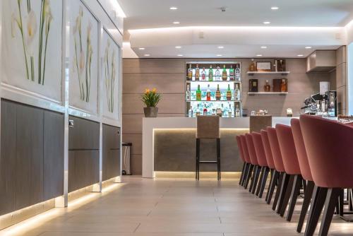 a bar in a restaurant with pink chairs at Hotel La Giocca in Rome