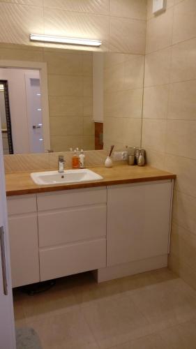 La salle de bains est pourvue d'un lavabo et d'un miroir. dans l'établissement Apartament z widokiem na Jezioro, à Olecko