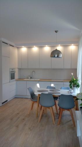 a kitchen with a table and chairs in a kitchen at Apartament z widokiem na Jezioro in Olecko