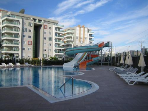 a swimming pool with a slide in a resort at Emerald Towers Residence in Avsallar