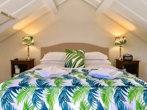 a bedroom with a large bed with a tropical bedspread at The Horseshoe Country Inn in Pickering