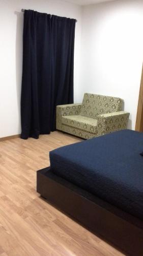 a bedroom with a bed and a couch and a chair at Casal da Porta - Quinta da Porta in Mirandela