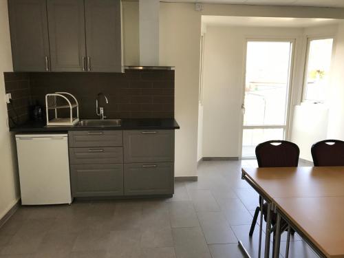 a kitchen with a sink and a table with chairs at Kalmar Hotell in Kalmar