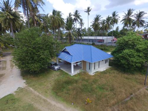 una vista aérea de una casa con techo azul en Maxim Apartment, en Pantai Cenang