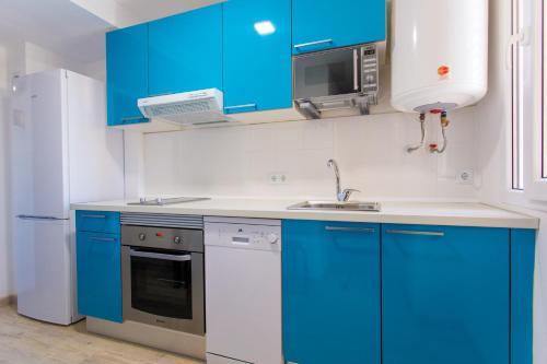 バレンシアにあるVersus Apartment near City of Artsのキッチン(青いキャビネット、シンク、冷蔵庫付)