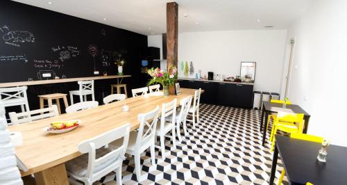 a dining room with a wooden table and chairs at The Black Sheep Hostel in Giethoorn